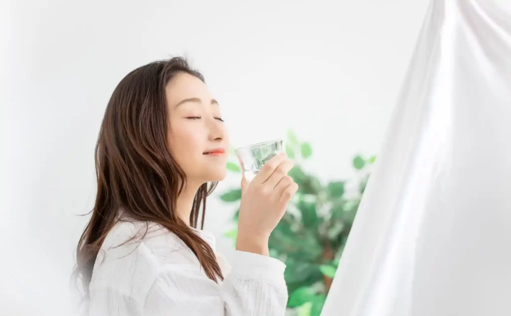 水素水ウォーターサーバーの水を飲んでいる女性
